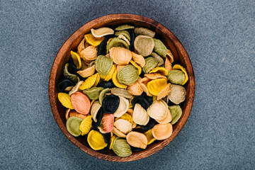 Traditional Italian Rainbow pasta. Colored raw pasta on a stone background