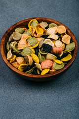 Traditional Italian Rainbow pasta. Colored raw pasta on a stone background