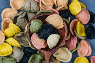 Traditional Italian Rainbow pasta. Colored raw pasta on a stone background