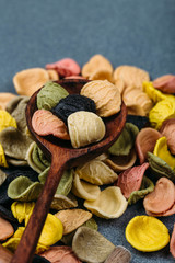 Traditional Italian Rainbow pasta. Colored raw pasta on a stone background