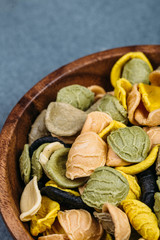 Traditional Italian Rainbow pasta. Colored raw pasta on a stone background