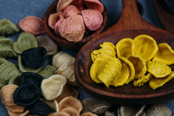 Traditional Italian Rainbow pasta. Colored raw pasta on a stone background
