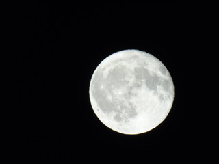 An amazing caption of the full moonlight over the city by night in summer days with some clouds and foggy