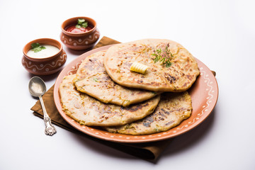 Aloo Paratha / Indian Potato stuffed Flatbread. Served with fresh curd and tomato ketchup. selective focus