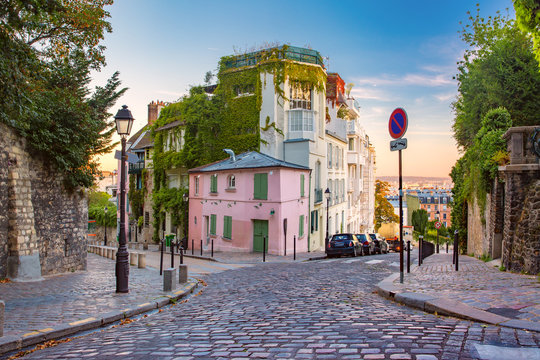 Fototapeta Cozy old street with pink house at the sunny sunrise, quarter Montmartre in Paris, France