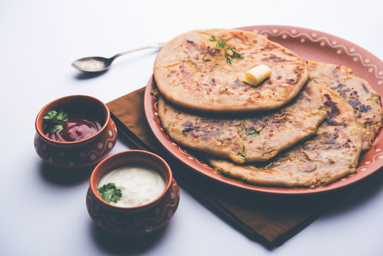 Aloo Paratha / Indian Potato stuffed Flatbread. Served with fresh curd and tomato ketchup. selective focus