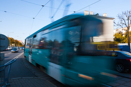 The motion of a blurred streetcar in the daytime.