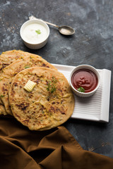 Aloo Paratha / Indian Potato stuffed Flatbread. Served with fresh curd and tomato ketchup. selective focus