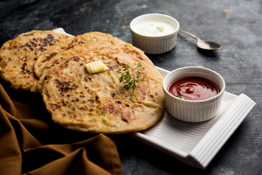 Aloo Paratha / Indian Potato stuffed Flatbread. Served with fresh curd and tomato ketchup. selective focus