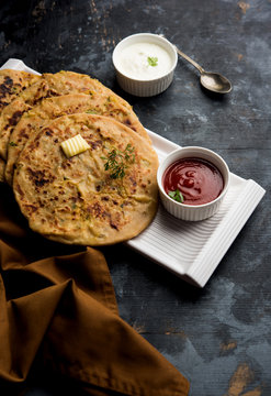 Aloo Paratha / Indian Potato stuffed Flatbread. Served with fresh curd and tomato ketchup. selective focus