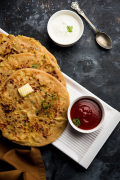 Aloo Paratha / Indian Potato stuffed Flatbread. Served with fresh curd and tomato ketchup. selective focus