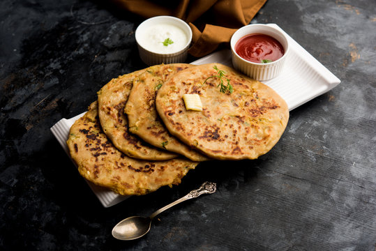 Aloo Paratha / Indian Potato stuffed Flatbread. Served with fresh curd and tomato ketchup. selective focus