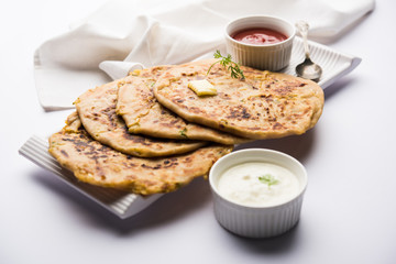 Aloo Paratha / Indian Potato stuffed Flatbread. Served with fresh curd and tomato ketchup. selective focus