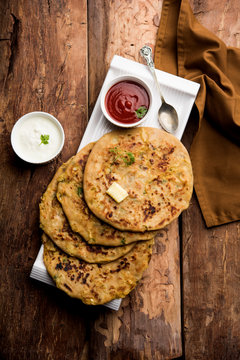 Aloo Paratha / Indian Potato stuffed Flatbread. Served with fresh curd and tomato ketchup. selective focus