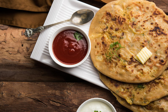 Aloo Paratha / Indian Potato stuffed Flatbread. Served with fresh curd and tomato ketchup. selective focus