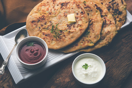 Aloo Paratha / Indian Potato stuffed Flatbread. Served with fresh curd and tomato ketchup. selective focus