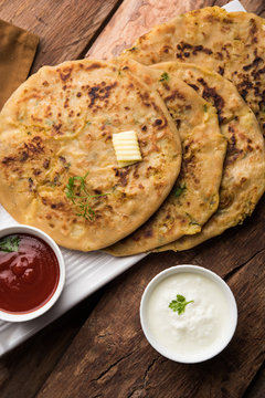 Aloo Paratha / Indian Potato stuffed Flatbread. Served with fresh curd and tomato ketchup. selective focus