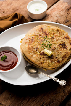 Aloo Paratha / Indian Potato stuffed Flatbread. Served with fresh curd and tomato ketchup. selective focus