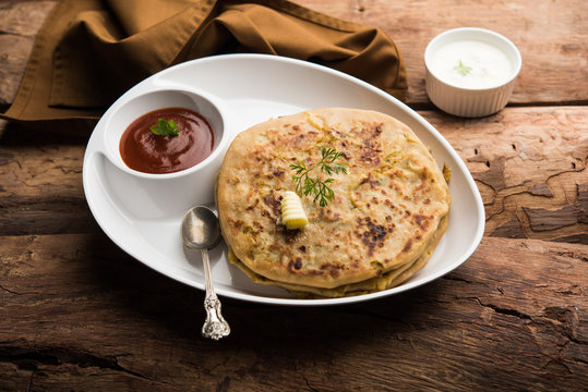 Aloo Paratha / Indian Potato stuffed Flatbread. Served with fresh curd and tomato ketchup. selective focus