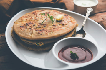 Aloo Paratha / Indian Potato stuffed Flatbread. Served with fresh curd and tomato ketchup. selective focus