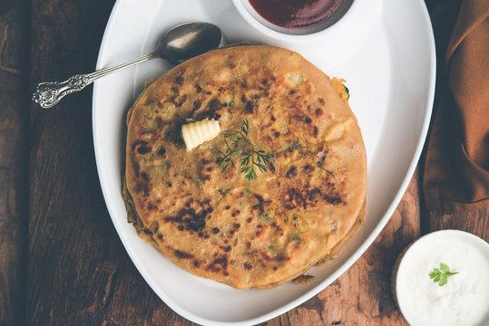 Aloo Paratha / Indian Potato stuffed Flatbread. Served with fresh curd and tomato ketchup. selective focus