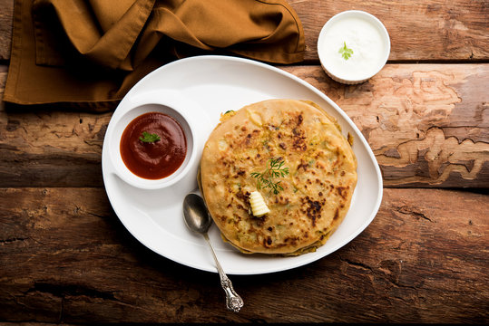 Aloo Paratha / Indian Potato stuffed Flatbread. Served with fresh curd and tomato ketchup. selective focus