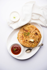 Aloo Paratha / Indian Potato stuffed Flatbread. Served with fresh curd and tomato ketchup. selective focus