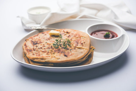 Aloo Paratha / Indian Potato stuffed Flatbread. Served with fresh curd and tomato ketchup. selective focus