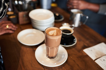 Customer collecting her drinks order at a cafe counter