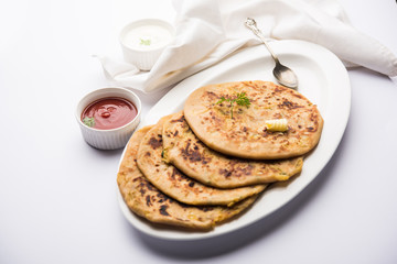 Aloo Paratha / Indian Potato stuffed Flatbread. Served with fresh curd and tomato ketchup. selective focus