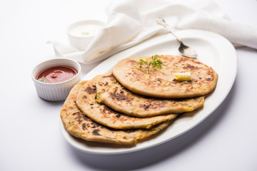 Aloo Paratha / Indian Potato stuffed Flatbread. Served with fresh curd and tomato ketchup. selective focus