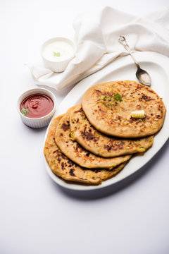 Aloo Paratha / Indian Potato stuffed Flatbread. Served with fresh curd and tomato ketchup. selective focus