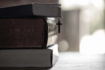 Close up cross with holy bible on wooden table. Christian concept