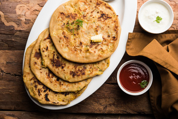 Aloo Paratha / Indian Potato stuffed Flatbread. Served with fresh curd and tomato ketchup. selective focus