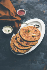 Aloo Paratha / Indian Potato stuffed Flatbread. Served with fresh curd and tomato ketchup. selective focus