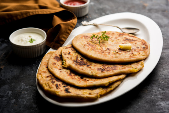 Aloo Paratha / Indian Potato stuffed Flatbread. Served with fresh curd and tomato ketchup. selective focus