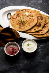 Aloo Paratha / Indian Potato stuffed Flatbread. Served with fresh curd and tomato ketchup. selective focus