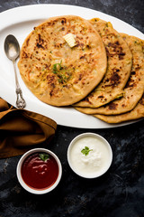 Aloo Paratha / Indian Potato stuffed Flatbread. Served with fresh curd and tomato ketchup. selective focus