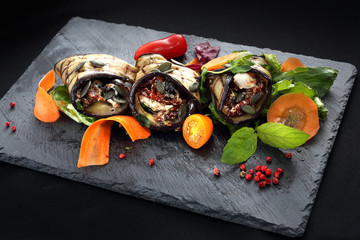 Warzywne roladki. Roladki z grillowanego bakłażana z suszonymi pomidorami i serem podane na sałacie i marchewce.