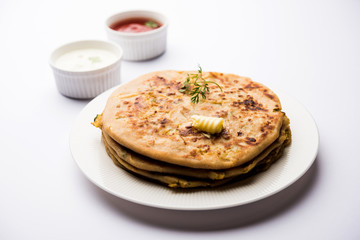Aloo Paratha / Indian Potato stuffed Flatbread. Served with fresh curd and tomato ketchup. selective focus