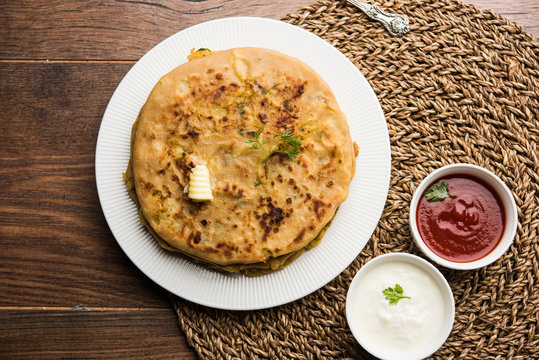 Aloo Paratha / Indian Potato stuffed Flatbread. Served with fresh curd and tomato ketchup. selective focus