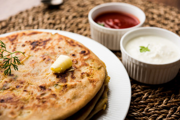 Aloo Paratha / Indian Potato stuffed Flatbread. Served with fresh curd and tomato ketchup. selective focus