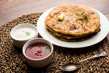 Aloo Paratha / Indian Potato stuffed Flatbread. Served with fresh curd and tomato ketchup. selective focus