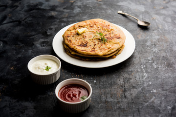 Aloo Paratha / Indian Potato stuffed Flatbread. Served with fresh curd and tomato ketchup. selective focus