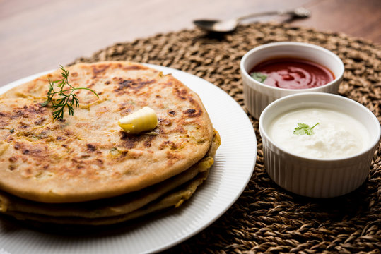Aloo Paratha / Indian Potato stuffed Flatbread. Served with fresh curd and tomato ketchup. selective focus