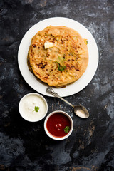 Aloo Paratha / Indian Potato stuffed Flatbread. Served with fresh curd and tomato ketchup. selective focus
