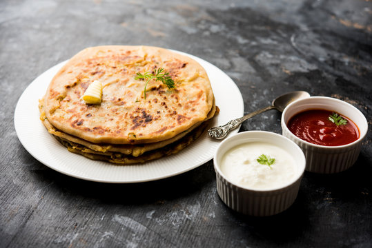 Aloo Paratha / Indian Potato stuffed Flatbread. Served with fresh curd and tomato ketchup. selective focus