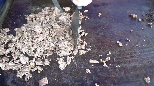 Chopping A Cheese Steak On A Griddle