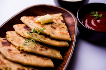 Aloo Paratha / Indian Potato stuffed Flatbread. Served with fresh curd and tomato ketchup. selective focus