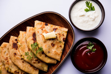 Aloo Paratha / Indian Potato stuffed Flatbread. Served with fresh curd and tomato ketchup. selective focus